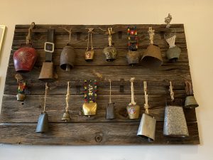 a collection of cow bells hanging up inside the pizza barn